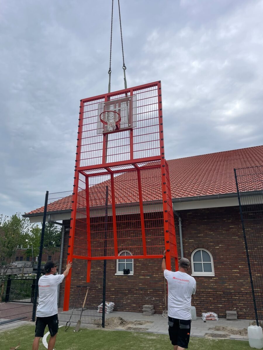 Sportkooi met voetbal- en basketbalcombinatie geplaatst bij Herderscheeschool Almelo 5 Plaatsing Sportkooi van 9 x 17 meter met basketbalunits, voetbaldoelen en antraciet hekwerk bij de Herderscheeschool in Almelo.